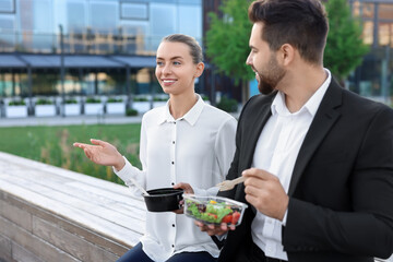 Smiling business woman talking with her colleague during lunch outdoors