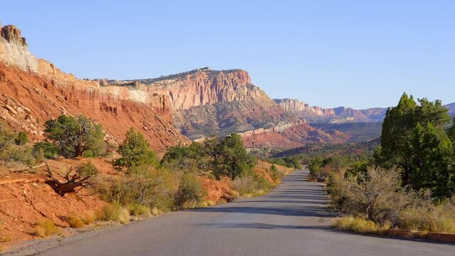 Establishing shot of mountains with red rocks background in Fruita Scenic Road, Capital Reef National Park, Utah, North America. Day time on October 2023. Still camera view. ProRes 422 HQ.