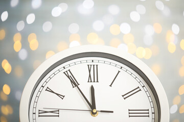Obraz na płótnie Canvas Clock showing five minutes until midnight on blurred background, closeup. New Year countdown