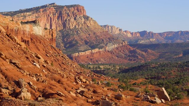 Establishing shot of mountains with red rocks background in Fruita Scenic Road, Capital Reef National Park, Utah, North America. Day time on October 2023. Still camera view. ProRes 422 HQ.