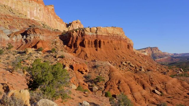 Establishing shot of mountains with red rocks background in Fruita Scenic Road, Capital Reef National Park, Utah, North America. Day time on October 2023. Still camera view. ProRes 422 HQ.