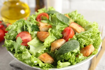 Delicious salad with chicken, cherry tomato and spinach on table, closeup