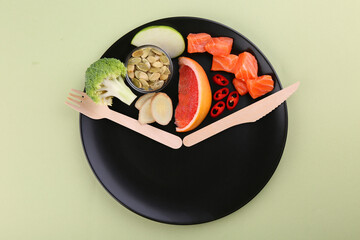 Metabolism. Plate with different food products and wooden cutlery on light background, top view