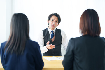 先生と進路相談をする女の子とお母さん