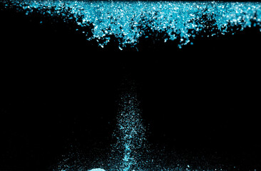 Explosion metallic blue glitter sparkle. sky Glitter powder spark blink celebrate, blur foil explode in air, fly throw blue glitters particle. Black background isolated, selective focus Blur bokeh