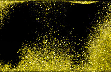 Explosion metallic gold glitter sparkle. Golden Glitter powder spark blink celebrate, blur foil explode in air, fly throw gold glitters particle. Black background isolated, selective focus Blur bokeh