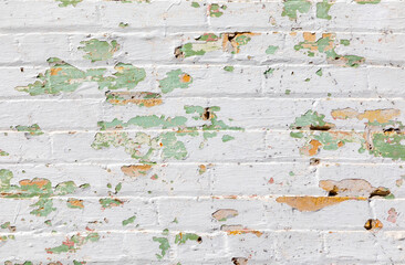 brick wall background with many layers ofin different color of old peeling paint