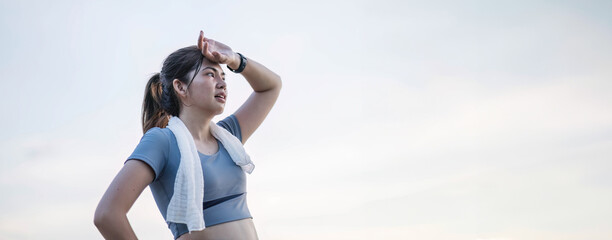 Asian woman is exhausted and wipes away sweat after running, jogging, exercising or exercising in the morning. sports for health Tired and out of breath Freshness and sweating