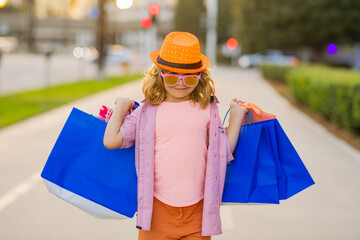 Shopping bag. Fashion child model. Kid with shopping bags. Fashion and sale.