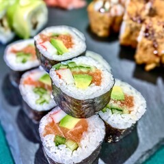 Japanese food. Sushi rolls with eel, avocado, cream cheese and cucumber on a black background.