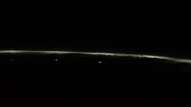 Vertical drone footage of deserted street at night. Vertical video of a row of street lights on the edge of Lake Limboto, Gorontalo-Indonesia