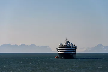 Fotobehang Large cruise ship in the calm ocean outside Longyearbyen, Svalbard in the arctic early in the morning on a summer day  © knelson20