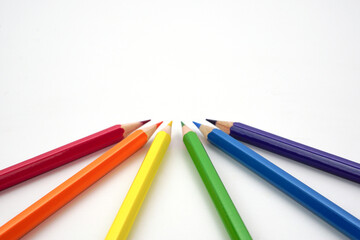 Top view of colored pencils or pastel on white background. Learning, study and presentation concept.