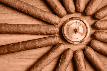Zelfklevend Fotobehang Cigars with humidor hygrometer on the wooden background. Image toned in Peach Fuzz color of the year 2024. © JuliaDorian