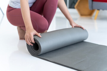 Young women rolling yoga or fitness mat - 690473169