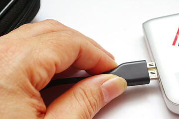 Close up of a man's hand holding a USB flash drive or USB cable 2