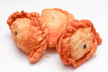 Fried flour snack or curry puff filled with chicken, a popular snack in Thailand. placed on a white...