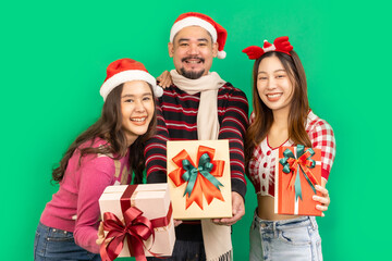 Asian people couple hold boutique bags pile stack newyear giftbox isolated on green color background. Happy New Year celebration Christmas holiday.