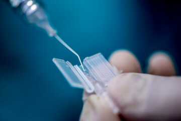 Nurse preparing synthetic lens to replacing human lens replaced during a cataract removal...