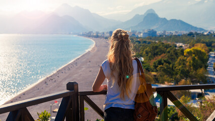 Young female tourist enjoying panoramic view of Antalya beach at sunset- Turkey - obrazy, fototapety, plakaty