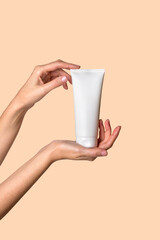 Woman hand showing cream product. Cosmetic product branding mockup. Daily skincare and body care routine. Female hand holding cosmetic product mockup on beige background