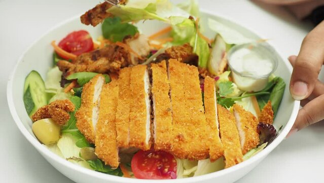 eating vegetable salad with fried chicken 