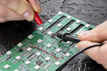 Chip repair. The master tests the LEDs on the microcircuit using a multi-meter. Checking LEDs. LEDs...