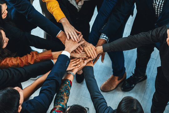 A group of diversity people putting their hands together. Showing unity teamwork and friendship. Close up top view of young business man and business woman joining as a team. Intellectual.