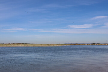 coastal bay landscape with pellicans in background and people enjoying leisure activities