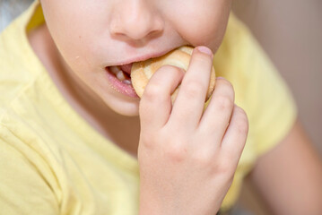 Close up of a mouth of a caucasian little child eating biscuits