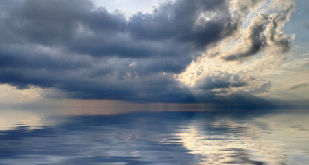 Dramatic dark clouds over the sea with  spots of light on the water, wide view.