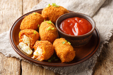 Italian Rice balls stuffed with mozzarella cheese and deep fried closeup on the plate on the table....