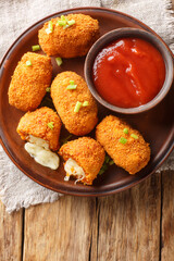 Suppli al telefono from Rome consists of deep-fried risotto rice with bolognese sauce and melting mozzarella closeup on the plate on the table. Vertical top view from above