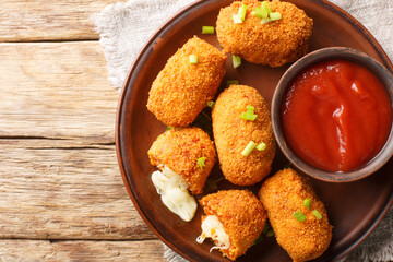 Naklejka premium Italian Rice balls stuffed with mozzarella cheese and deep fried closeup on the plate on the table. Horizontal top view from above