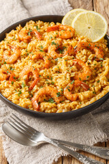 Italian Risotto ai Gamberi or Shrimp Risotto a closeup on the plate on the wooden table. Vertical