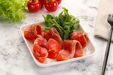 Sliced salmon with fresh arugula