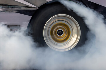 Car burnout wheels tire with white smoke,Car wheel burnout with smoke from the spinning tyre, Drag car wheel burns tires preparation for the race. - obrazy, fototapety, plakaty