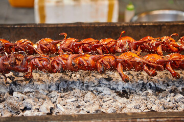 Quails spinning on grill at street food