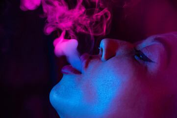 Close up portrait of asian woman with short hair smoking in neon light. 