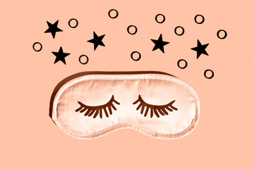 Sleep mask with eyelashes. Flat lay, close-up. Peach fuzz is color of year 2024.