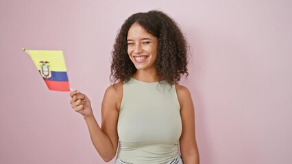 Radiant and confident young hispanic woman, beaming with joy as she proudly holds a colombian flag against an isolated pink wall. - Powered by Adobe