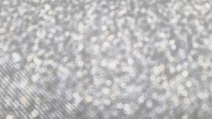 The abstract background is a gray fabric texture that has been defocused.