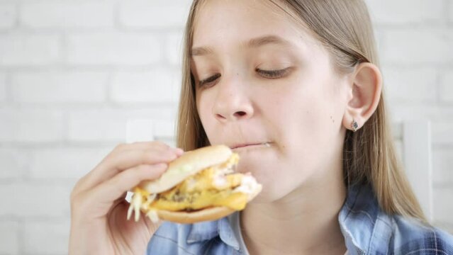 Kid Eating Fast Food, Child Eats Hamburger in Restaurant, Hungry Teenager Blonde Girl with Cheeseburger Sandwiches, Drinking Juice