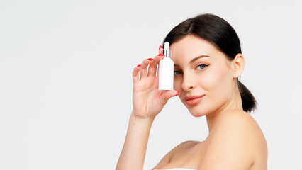 Women's cosmetic procedures. A young attractive, charismatic woman shows a serum or oil for her...