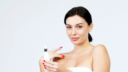 Women's cosmetic procedures. A young attractive, charismatic woman shows a serum or oil for her...