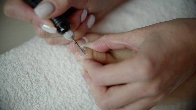 Using Electric Drill Machine Doing Pedicure. Woman Removing Cuticle Skin On Big Toe. Foot Care 