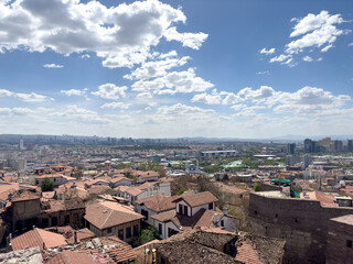 Aerial view of a village in Izmir, Turkey, with old houses and a blue sky with clouds.