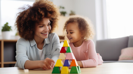 Obraz premium Happy African mother and children playing with building blocks, cute little girl playing with toy block and enjoying time together at home