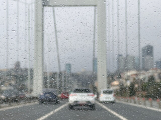 rain drops on windscreen over blurred cars on the road