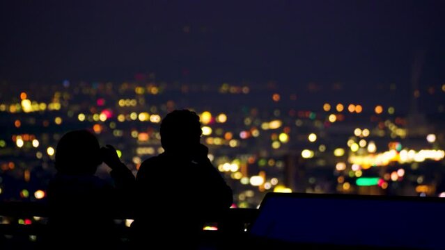 美しい夜の都市風景を眺めながらデートをする恋人たち
